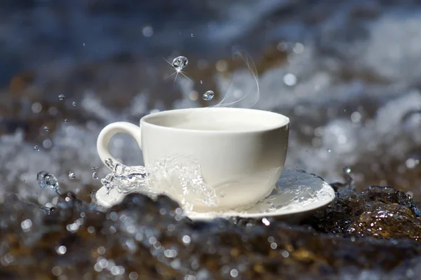 Refresca a água e xícara de café nas rochas nas cachoeiras — Fotografia de Stock