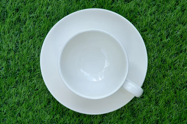 Blank white coffee cup on the artificial grass. — Stock Photo, Image