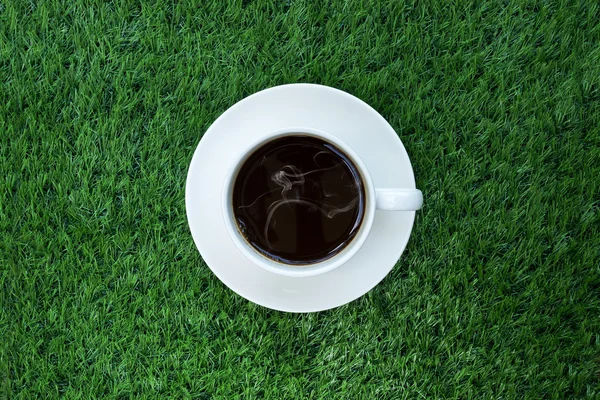 Coffee cup on artificial grass — Stock Photo, Image