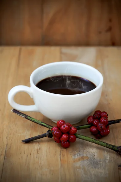 Varmt kaffe på trä och råa kaffebönan. — Stockfoto