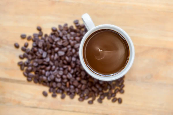 Cafea caldă pe lemn și boabe de cafea prăjită . — Fotografie, imagine de stoc