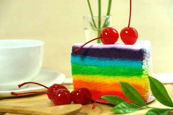 Rainbow cake with cherries — Stock Photo, Image