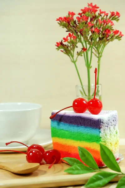 Rainbow cake with cherries — Stock Photo, Image