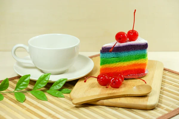 White coffee cup and Rainbow cake with red cherries — Stock Photo, Image