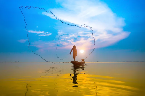 Balık ağlarına günbatımı sırasında atma siluetleri balıkçı. — Stok fotoğraf