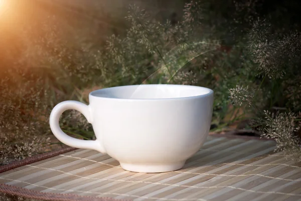 Tazza di caffè con erba piccolo fiore — Foto Stock