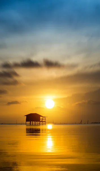 Antigua casa de campo en el lago y el cielo puesta de sol . — Foto de Stock