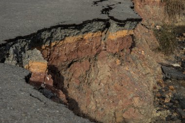 Çökmüş ve düşmüş kırık asfalt yolun kenarında