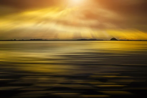 Sylwetki piękny złoty zachód słońca w morzu z nasyconych — Zdjęcie stockowe