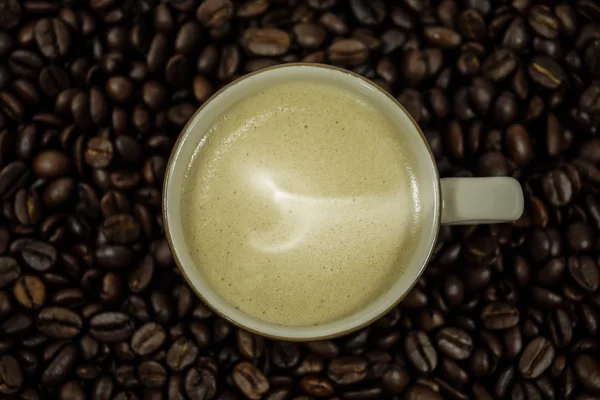 Warme koffie in de koffie bonen. — Stockfoto