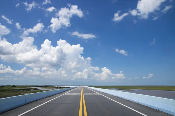 Leere Straße und die gelben Verkehrslinien mit blauem Himmel. — Stockfoto