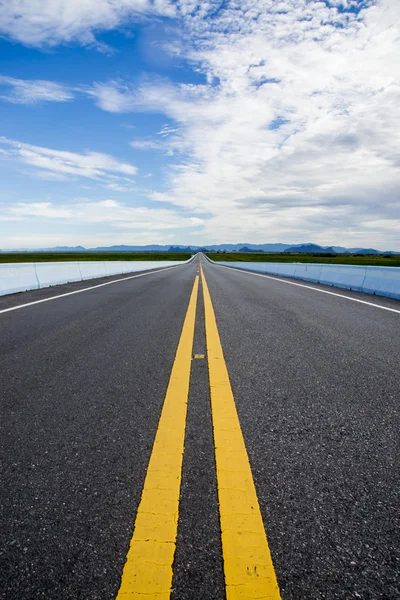 Route vide et les lignes de circulation jaunes — Photo