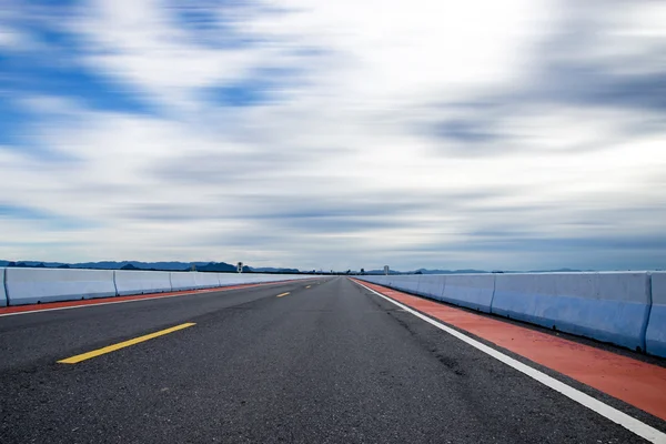 Motion cloud over Empty road and the yellow traffic lines — Stockfoto