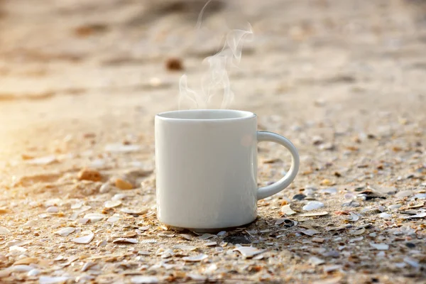 Kubek biały kawy na plaży. — Zdjęcie stockowe