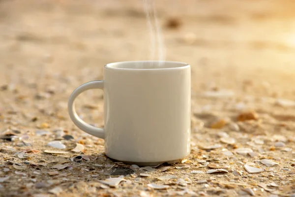 Vit kaffekopp på stranden. — Stockfoto