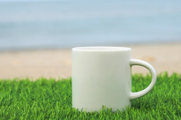 Vit kaffekopp på stranden — Stockfoto