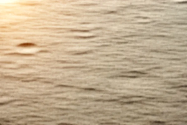 Размытое изображение песочного узора на пляже летом и солнечный свет — стоковое фото