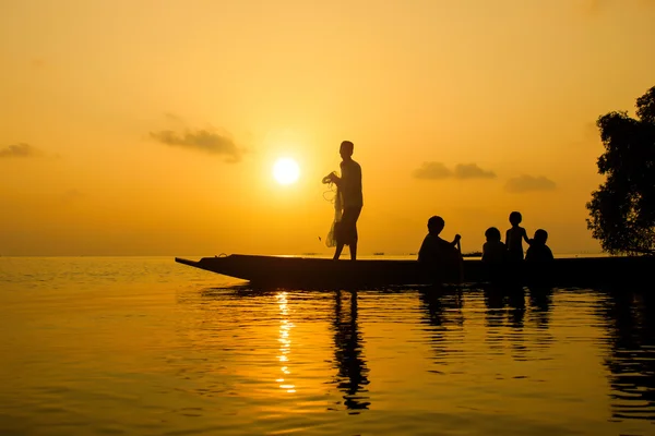 Silhouetten visser en familie op het meer, Thailand. — Stockfoto