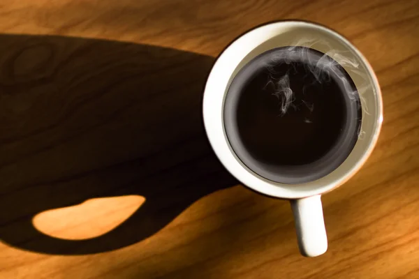 Coffee and shadows on the wooden. — Stock Photo, Image