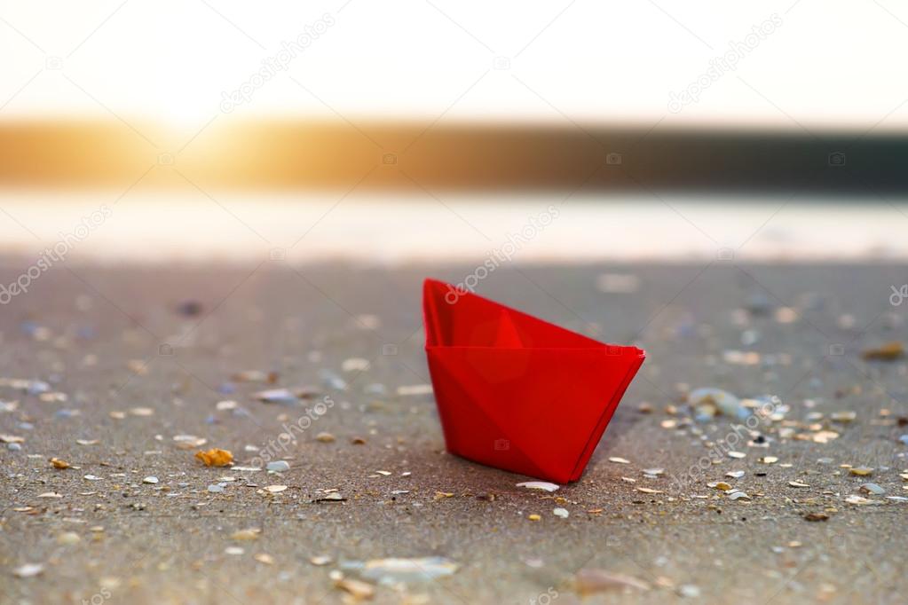 Red paper boats on beach outdoors.
