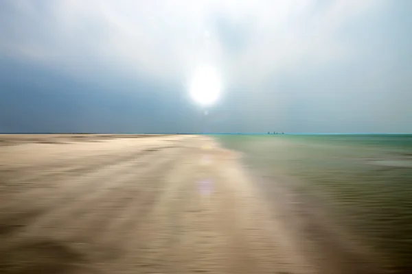 Areia em movimento e água na praia com sol . — Fotografia de Stock