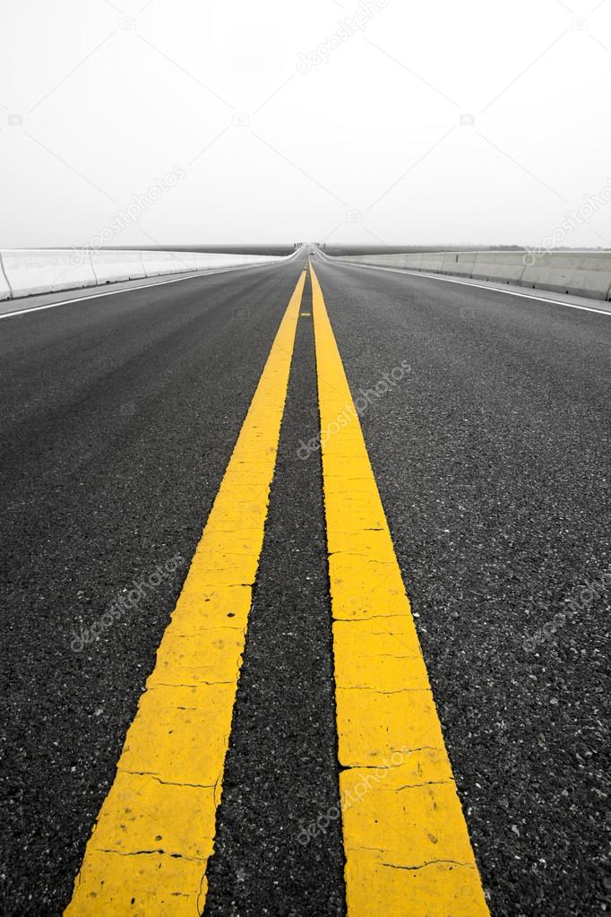 Empty road and old yellow traffic lines