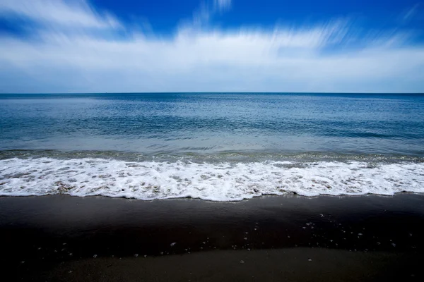 黒砂ビーチとモーションの雲の上. — ストック写真