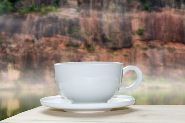 Beyaz kahve fincanı ile dağ arka plan bulanıklık.