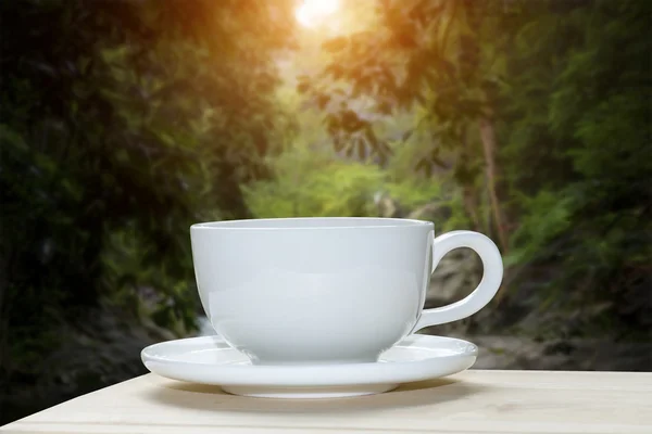 White coffee cup with blur of forest background. — Stock Photo, Image