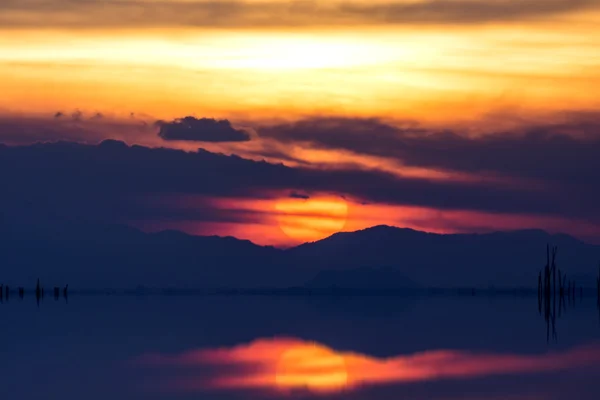 Solnedgång vid sjön i ett töcken. — Stockfoto