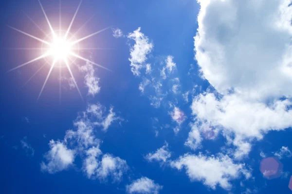 Blauer Himmel mit weißen Wolken und Sonne. — Stockfoto