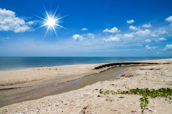 Blauwe hemel en kleine kanaal op het strand met zon. — Stockfoto