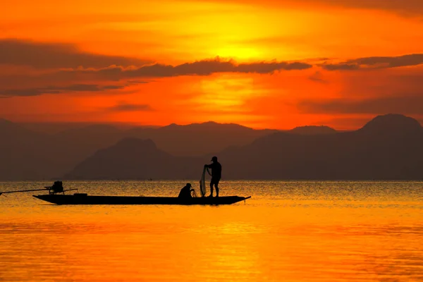 Silhouette di pescatore al lago con tramonto, Thailandia . — Foto Stock