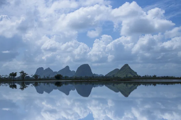 Reflexion des Himmels auf der Wasseroberfläche mit Bergen und Wolken. — Stockfoto