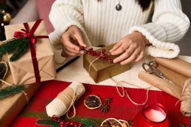 Eller güzelce paketlenmiş hediyeleri dikkatlice düzenler, bayram ruhunu kucaklar..