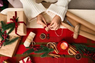 Eller hediyeleri Noel süsüsüyle güzelce sarıp, Noel zamanı sıcak bir ortam yaratıyor..