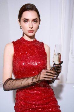 Neşeli bir kutlamanın ortasında elinde kadehle şenlik giysileri içinde parlayan genç bir kadın..