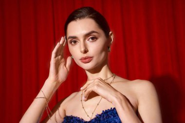 Şenlikli giyinmiş genç, güzel bir kadın canlı bir arka plana zarif bir şekilde gülümsüyor..