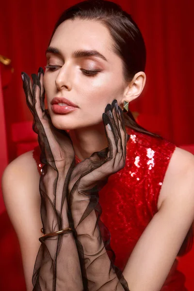 Kırmızı pullu genç bir kadın zarif siyah eldivenli, neşeli bir atmosferden hoşlanıyor..