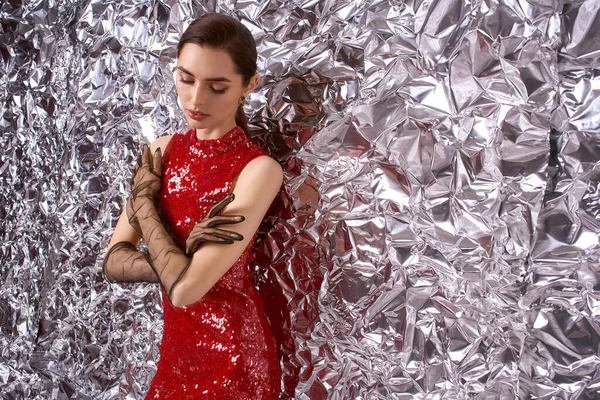 Parlak kırmızı elbiseli genç bir kadın festival atmosferinde zarafet saçıyor..