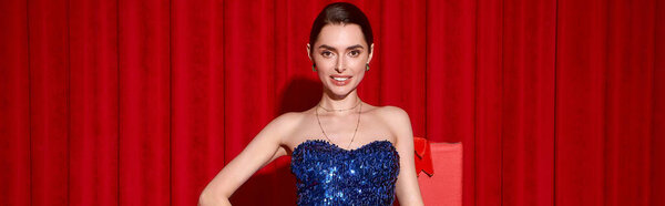 Красивая молодая женщина в ослепительно синем платье наслаждается праздничным праздником, излучающим радость.