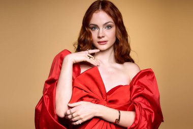 Kızıl saçlı genç bir kadın zarif kırmızı bir fiyonk giyer, Noel ruhunu ve neşesini somutlaştırır..