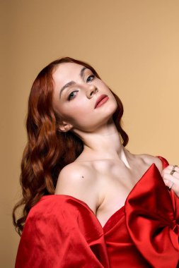 Bu çarpıcı kızıl saçlı genç kadın büyük kırmızı bir fiyonk sergiliyor, neşeli bir tezahürat yapıyor..