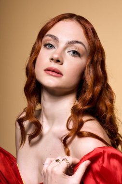 Neşeli, kızıl saçlı genç bir kadın neşeli kırmızı bir fiyonkta parlıyor, bayram neşesini kucaklıyor..