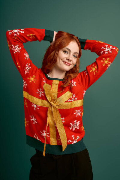 Веселая рыжая позирует в уютном рождественском свитере, празднуя зимний сезон.