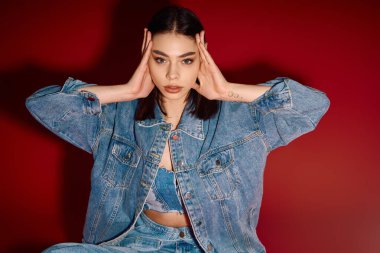 Genç bir kadın şık kotlarını canlı bir stüdyoda sergiliyor..