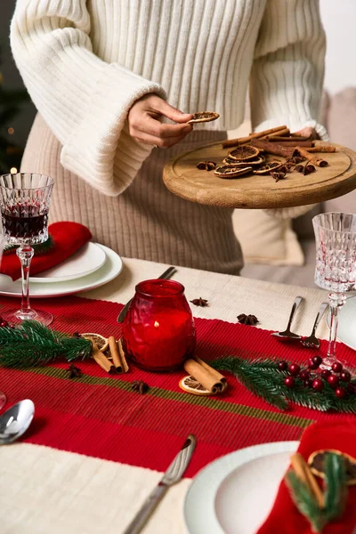 Радісне зібрання відбувається, коли людина подає святкові закуски на красиво встановленому столі. — стокове фото