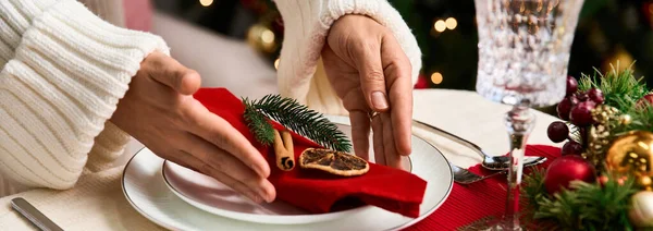 Manos cuidadosamente la organización de elementos decorativos en una mesa de Navidad bellamente establecido. - foto de stock