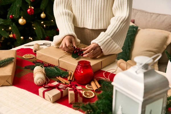 Envolver regalos con decoración navideña, creando un ambiente cálido y festivo para la Navidad. - foto de stock