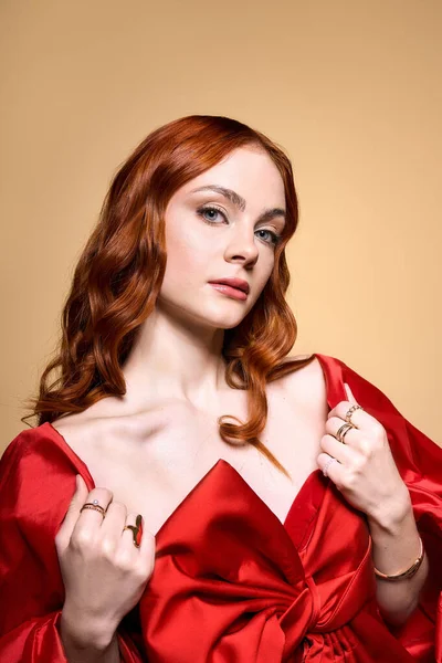 Eine rothaarige Frau präsentiert elegant ihren Urlaubsstil mit einer festlichen roten Schleife. — Stockfoto